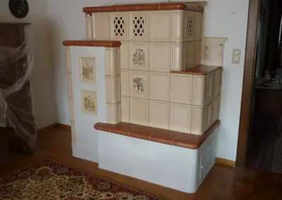 Fertig aufgebauter Kachelofen mit heller Keramikverkleidung und Sitzbank.