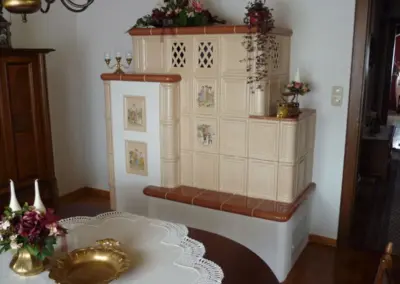 Kachelofen mit heller Keramikverkleidung, Sitzbank.