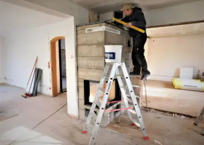Aufbau eines modernen Kamins durch Fachhandwerker von AKM Masche während der Montage in einem Wohnraum.