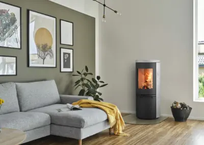 HETA Scan-Line 900 Kaminofen mit Specksteinverkleidung, hoher Sichtscheibe und sichtbarem Feuer im Wohnraum.