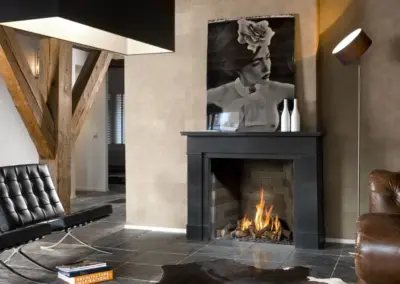 BRUNNER Gaskamin mit dunkler Verkleidung, großer Sichtscheibe und sichtbarem Feuer im modern gestalteten Wohnraum.