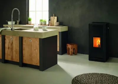 RIKA SUMO Pelletofen mit schwarzem Korpus und sichtbarem Feuer in einer modern gestalteten Wohnküche.